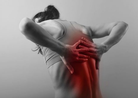 Woman clutching upper back with visible red pain highlight area